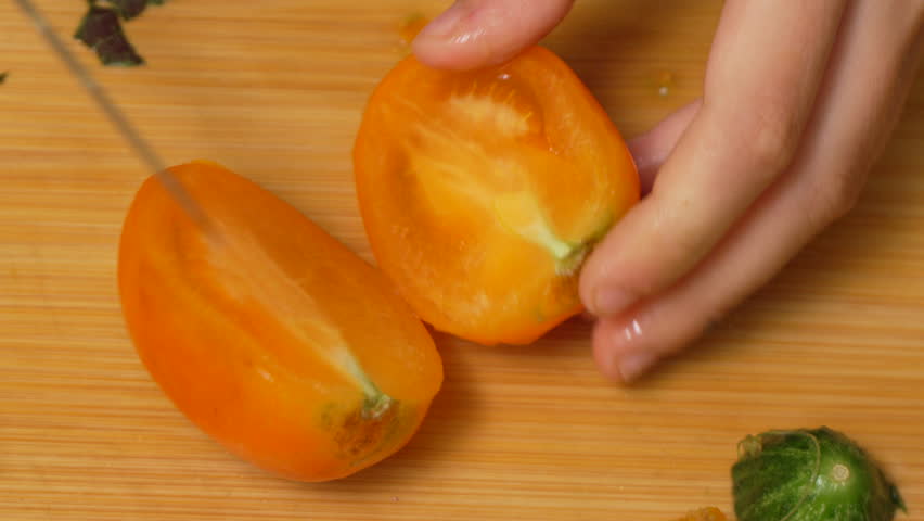 Cutting a Yellow Tomato on a Wooden Cutting Board