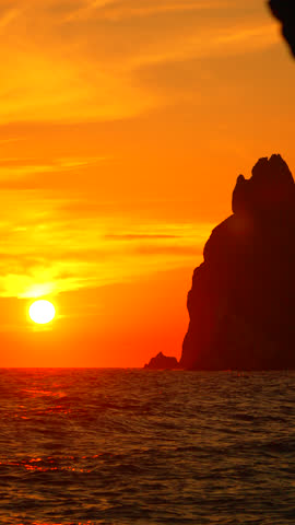 Sunset Rocks Ocean: Vibrant sunset illuminating coastal rocks at sea during golden hour.