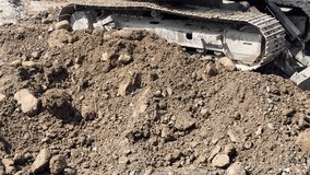 Front loader tractor scoops dirt and rocks on construction site, lifting and dumping off-camera into dump truck. - Powered by Shutterstock - Get 15% off with code: PIKWIZARD15