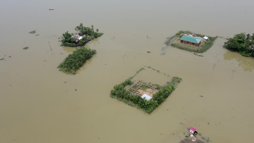 Aerial view over boat leaving flood affected submerged village home in Bangladesh community