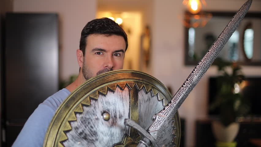 Adult man playing with medieval times sword and shield 
