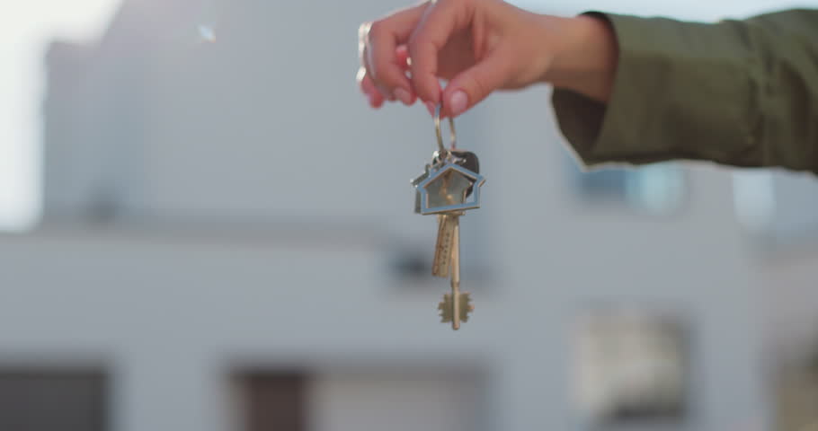 Woman holding keys to new house. Moving to a new home, mortgage, buying real estate, renting and booking housing, dream of living in the village.