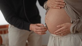 Pregnant woman and man in room, listening to baby heartbeat with stethoscope, creating an intimate moment in a home setting, highlighting pregnancy and couple's connection. - Powered by Shutterstock - Get 15% off with code: PIKWIZARD15