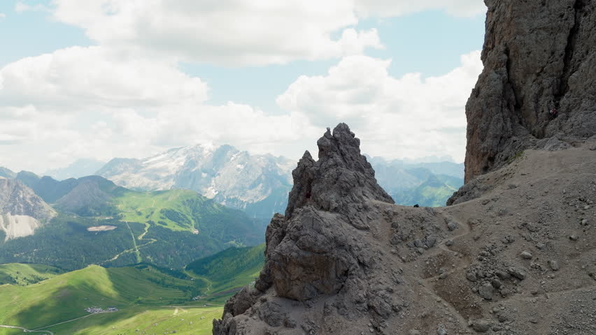 Slow panning drone shot of one man standing on top of Forcella del Sassolungo near Toni Demetz Hut, Dolomites, Italy