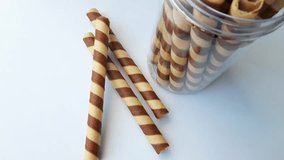 
footage of Close-up of delicious chocolate wafer rolls placed on a white base. Preparation of sweet dessert. Picking waffle rolls by hand - Powered by Shutterstock - Get 15% off with code: PIKWIZARD15