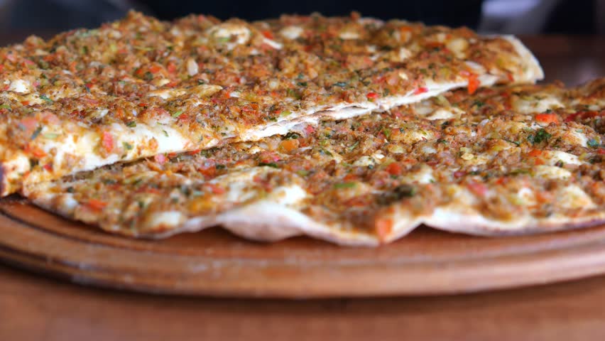 putting tomato and onion on Turkish pide 