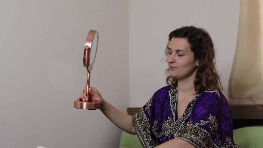 girl dresses non-la and looks in the mirror.