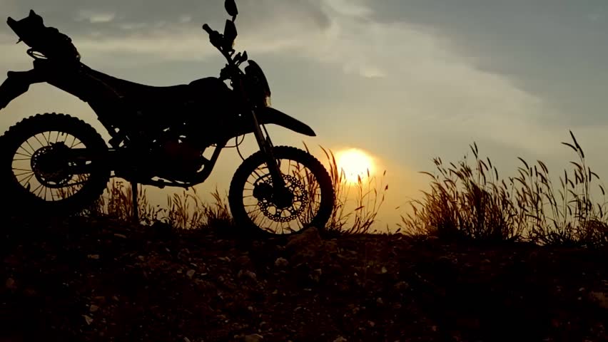 Silhouette of a Motorcycle: A powerful motorcycle silhouette dominates the foreground, set against a dramatic sunset backdrop, capturing the thrill of off-road adventures and the spirit of freedom.