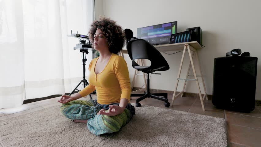 Meditation at work, Hispanic woman doing yoga breathing inside music production studio