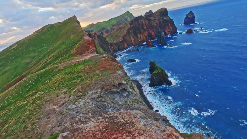 Aerial View of Coast with Green Grassy Hill and Red Soil – Stunning Nature Footage
This breathtaking aerial footage captures a unique coastal landscape, where vibrant green grasses cover a hill.