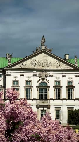 Old palace with pink blooming lilac in the park on a sunny day in Warsaw