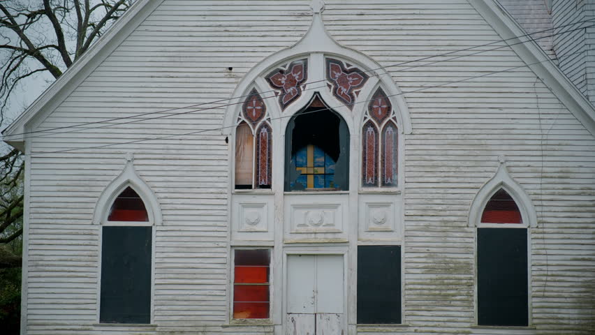 The crushed window of old abandoned building in small town.
