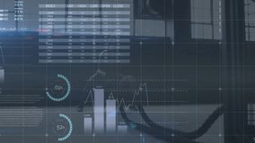 Analyst wearing hoodie sitting at desk, viewing transparent screen showing finance data charts. Technology, data visualization, finance, analysis, professional, modern, digital - Powered by Shutterstock - Get 15% off with code: PIKWIZARD15