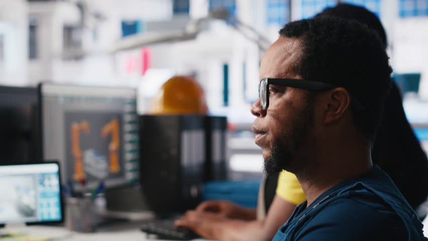 African american wheelchair user testing CAD software for manufacturing solar panels, factory engineer working in solar energy industry. Specialist with disability at the job. Camera A.