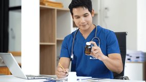 male medicine doctor, physician or practitioner in lab room writing on blank notebook and work on laptop computer with medical stethoscope on the desk at hospital. Medic tech concept. - Powered by Shutterstock - Get 15% off with code: PIKWIZARD15