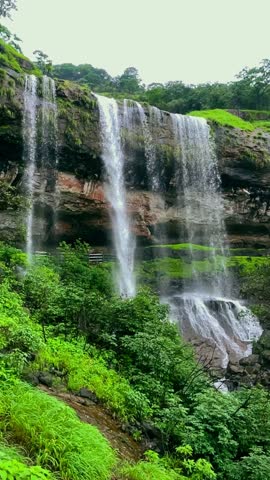 A breathtaking view of stunning waterfalls cascading through the lush green forests of Bhandardhara, Maharashtra, India, Water crashes over rugged cliffs creating a mesmerizing natural paradise