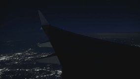 A stunning and beautiful night view from an airplane window as it descends, showcasing the sparkling city lights below in the distance - Powered by Shutterstock - Get 15% off with code: PIKWIZARD15