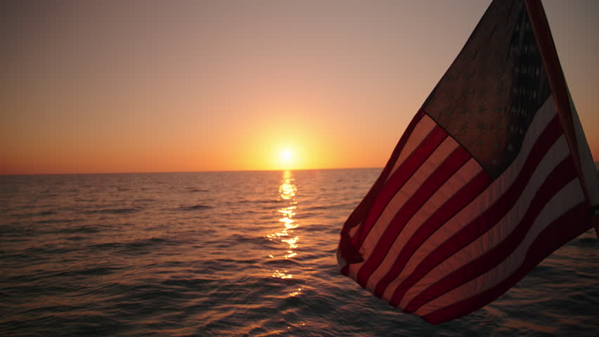 Experience the stunning beauty of a majestic sailing ship with an American flag at sunset in Key West, Florida. This tranquil moment is beautifully captured in slow motion for all to enjoy - Powered by Shutterstock - Get 15% off with code: PIKWIZARD15