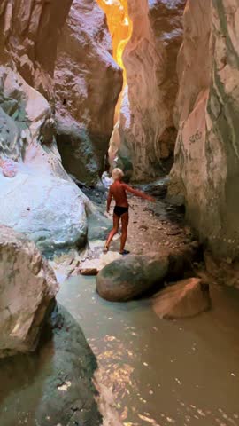 Saklikent National Park, or “hidden city", Turkey. A boy in the bed of the Yeshen River at the bottom of a gorge in Mugla province. The rocks are made of polished stone. The child is in the canyon. 4К