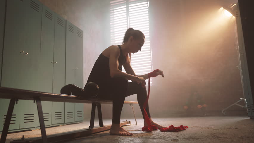 Exhausted sportswoman after hard cardio workout in changing room, be strong. Athletic feminine lady in skinny active wear, preparing to active boxing workout in gym, contrast of power and femininity