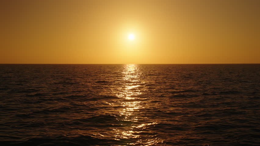 Experience the breathtaking beauty of a stunning sunset in slow motion, with tranquil ocean waves and a sky of glowing golden hues, capturing natures serenity and inspiring pure relaxation