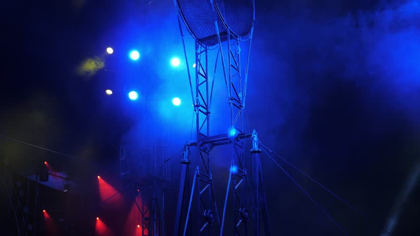 Circus equipment with professional lights and smoke in the circus. The rotating wheel of death, on which acrobats perform under the dome of the circus, bright concert lights. A circus show with smoke.