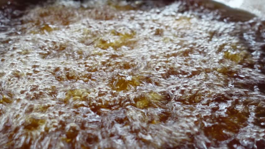 A CloseUp View of Bubbling Oil in a Frying Pan Captured in Detail