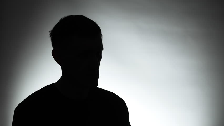 Anonymous interview with a man in a dark studio. Male silhouette.