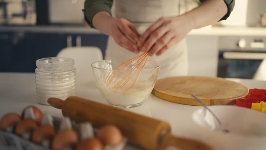 Woman adding egg and sugar to bowl with flour, preparing dough, following recipe