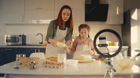 Happy mom and daughter recording cooking video for food blog, family time - Powered by Shutterstock - Get 15% off with code: PIKWIZARD15