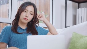 Young asian business woman working with laptop while thoughtful sitting on sofa in home office, businesswoman using on notebook in living room at home, woman thinking idea using laptop. - Powered by Shutterstock - Get 15% off with code: PIKWIZARD15