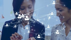 Two colleagues discussing data visualization in business meeting, showing floating network icons. Technology, collaboration, communication, innovation, professional, futuristic, networking - Powered by Shutterstock - Get 15% off with code: PIKWIZARD15