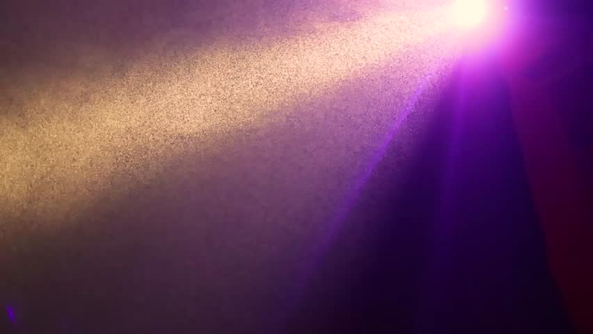 Stage or club purple lighting with a spotlight shining through smoke from a fog machine.