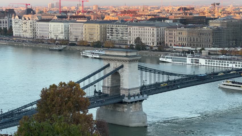 Suspension Szechenyi Chain Bridge of the 19th century over the River Danube in Budapest, Hungary, top view from the Castle Hill in autumn evening
