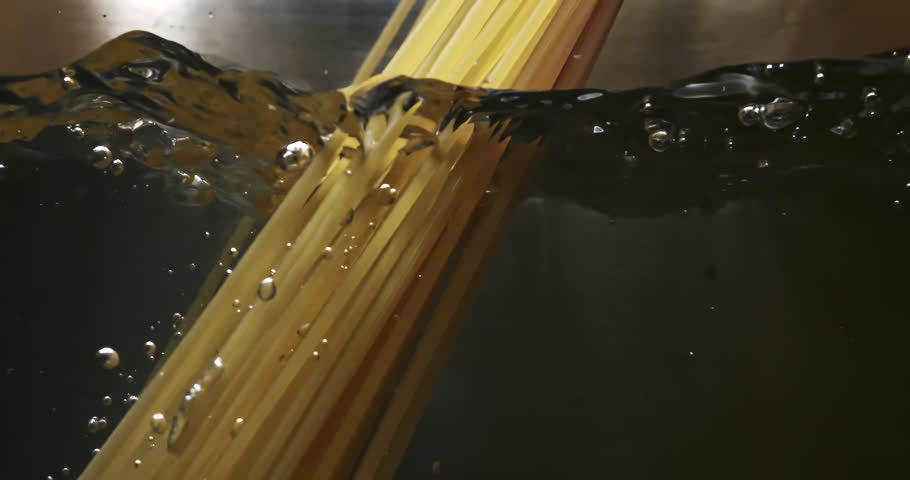 Slow Motion Close-Up of Spaghetti Dropping into Boiling Water. Italian Pasta Cooking Process, Capturing the Splash, Surface Tension and Start of Traditional Meal Preparation at 1000 fps.