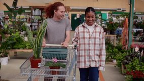 Customers enjoying choosing plants in a garden center, pushing a shopping cart and smiling at each other while selecting flowers and houseplants - Powered by Shutterstock - Get 15% off with code: PIKWIZARD15