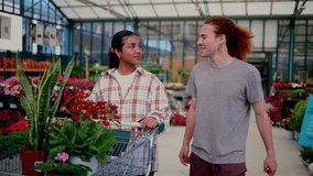 Cheerful multi ethnic couple navigating garden center, selecting vibrant flowers while sharing smiles and engaging in lively conversation near greenhouse displays - Powered by Shutterstock - Get 15% off with code: PIKWIZARD15