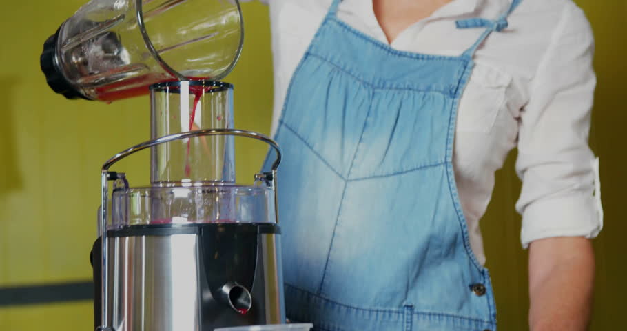 woman pouring smoothie mix into blender base in kitchen health demo, showing waveform overlays. Healthy, wellness, nutrition, lifestyle, modern, vibrant, domestic