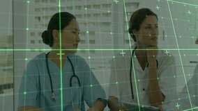 Medical professionals collaborating at conference, viewing tablet data with green grid overlay. Healthcare, teamwork, digital, analysis, collaboration, innovation, modern - Powered by Shutterstock - Get 15% off with code: PIKWIZARD15