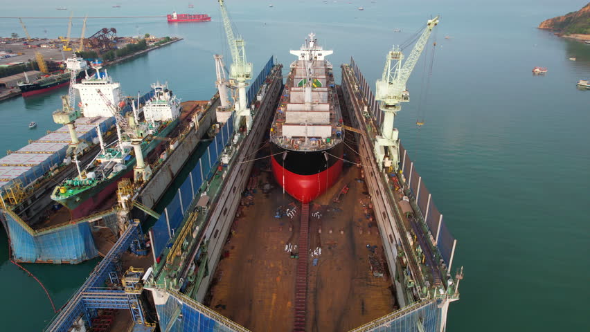 shipyard with cargo ships docked for repairs inside.
