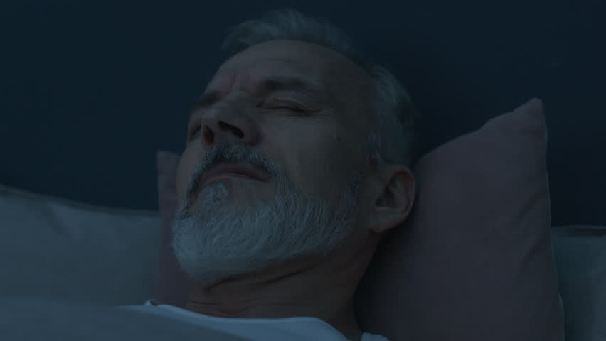 Close up shot of anxious senior man waking up from nightmare in bed, rubbing his face and trying to calm down during late night - Powered by Shutterstock - Get 15% off with code: PIKWIZARD15