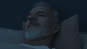 Close up shot of anxious senior man waking up from nightmare in bed, rubbing his face and trying to calm down during late night - Powered by Shutterstock - Get 15% off with code: PIKWIZARD15