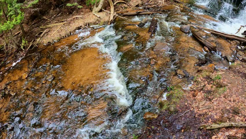 Wagner Falls flowing through forest at Pictured Rocks National Lakeshore in Michigan showing natural beauty and peaceful woodland.