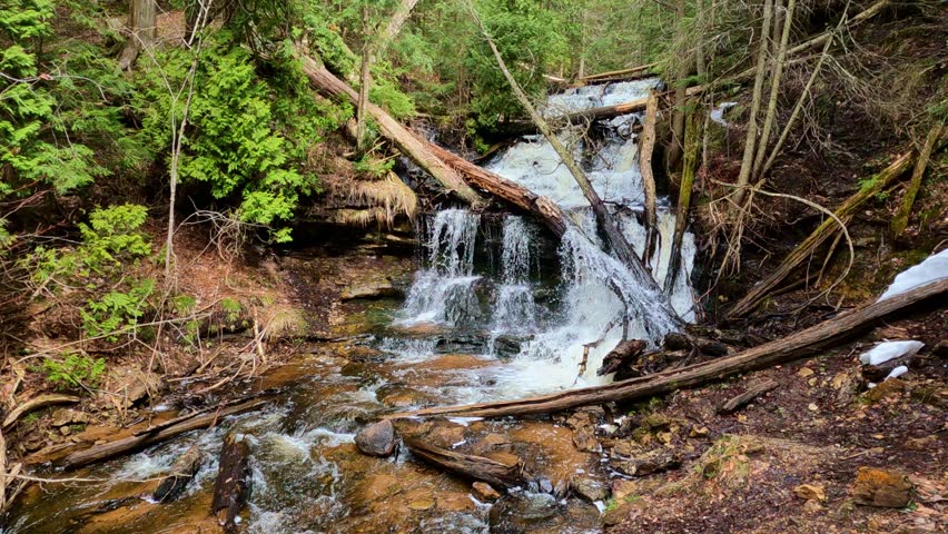 Wagner Falls flowing through forest at Pictured Rocks National Lakeshore in Michigan showing natural beauty and peaceful woodland.
