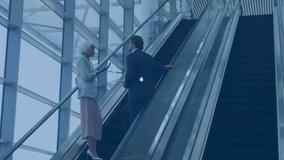 Two professionals riding escalators in corporate atrium, showing digital network connections. Business, network, architecture, collaboration, technology, modern, professional - Powered by Shutterstock - Get 15% off with code: PIKWIZARD15
