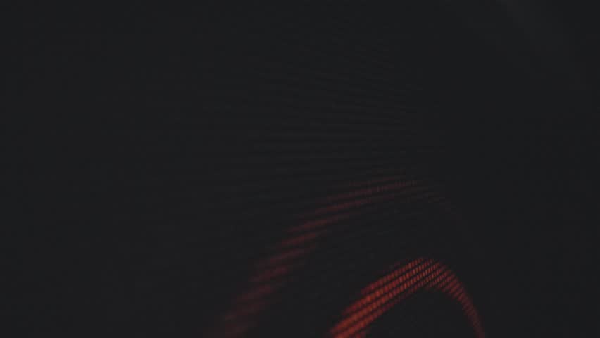 A digital abstract image featuring vibrant red and orange pixelated patterns on a dark background, creating a striking visual effect. Macro