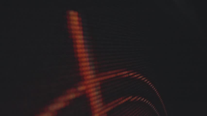 An abstract close up view of a speaker cone with vibrant orange lights, highlighting the mesh texture and circular design. Macro