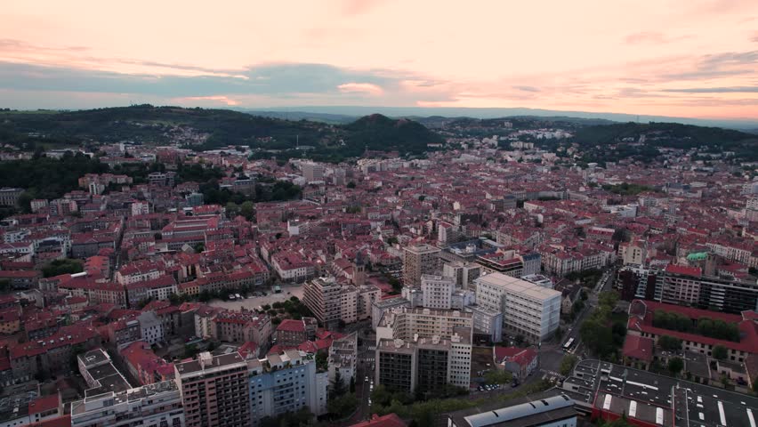 aerial shot revealing saint etienne skyline with the crassiers in the background and city center in the foreground at sunset, Loire departement, Auvergne Rhone Alpes region, France