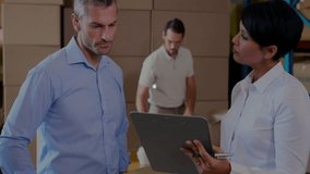 Coworkers discussing logistics data on laptop and tablet in warehouse showing glowing network links. Collaboration, technology, industrial, communication, analytics, teamwork, innovation - Powered by Shutterstock - Get 15% off with code: PIKWIZARD15