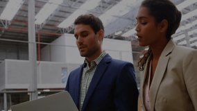 Team reviewing laptop data in manufacturing plant showing animated network graphics and user icons. Collaboration, industry, digital, technology, teamwork, skyscraper, innovation - Powered by Shutterstock - Get 15% off with code: PIKWIZARD15